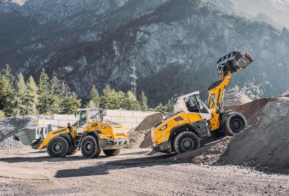 Gelbe Bagger baggern Schutt vor Bergkulisse