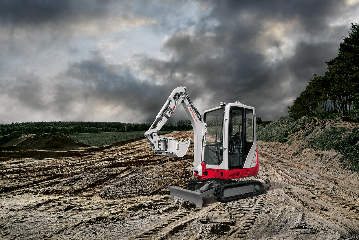 Ein rot weißer Bagger vor dunklen Wolken, im Hintergrund Bäume